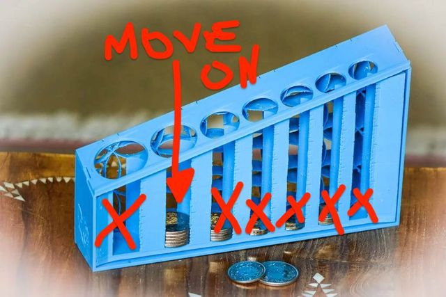Same coin sorter, with all slots crossed off except for the largest one with coins in it, and an arrow pointing at those coins that says 'move on'